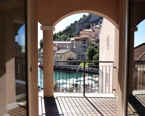 Ein Balkon mit Blick auf einen Pool und Gebäude im Hintergrund.