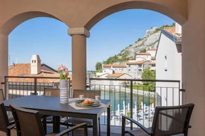 Ein Balkon mit Tisch, Stühlen und einer Blumenvase.