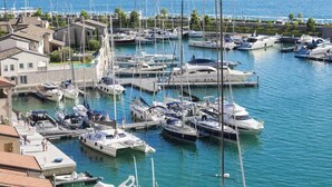 Ein Yachthafen mit verschiedenen Booten, ein Gebäude am Wasser und freie Sicht auf das Meer.