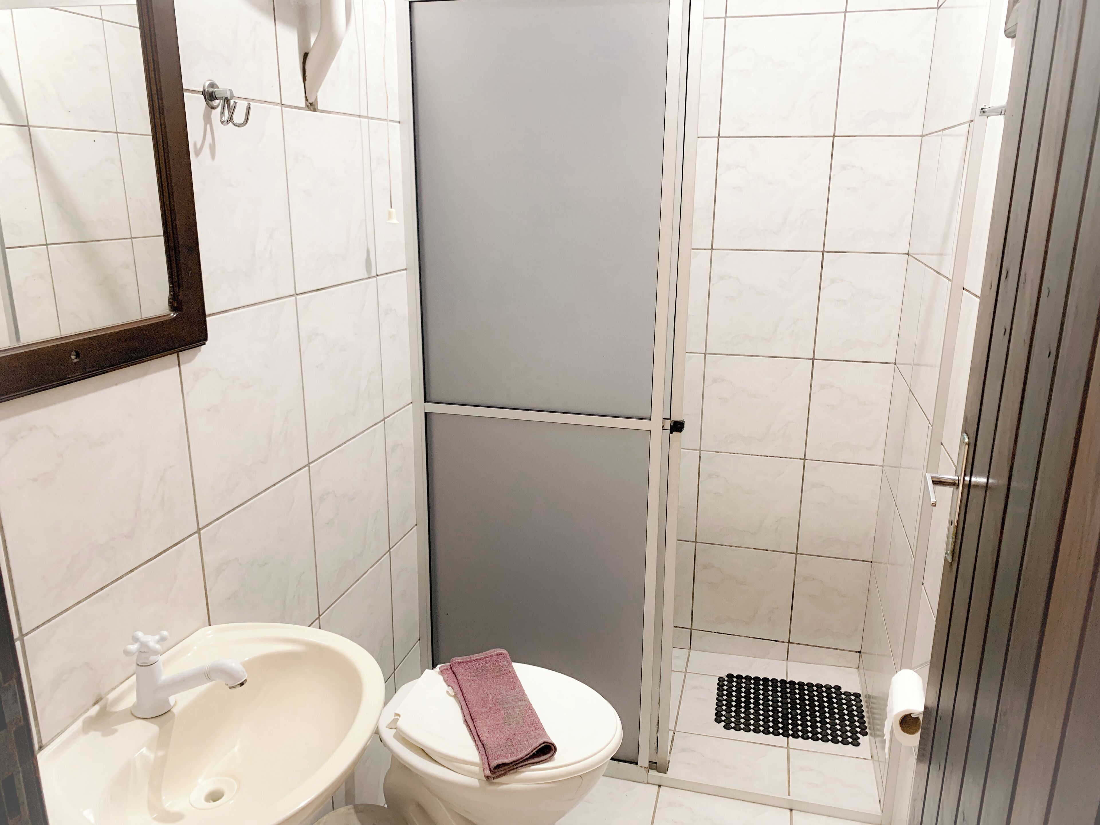 A bathroom with a sink, toilet, and shower area.