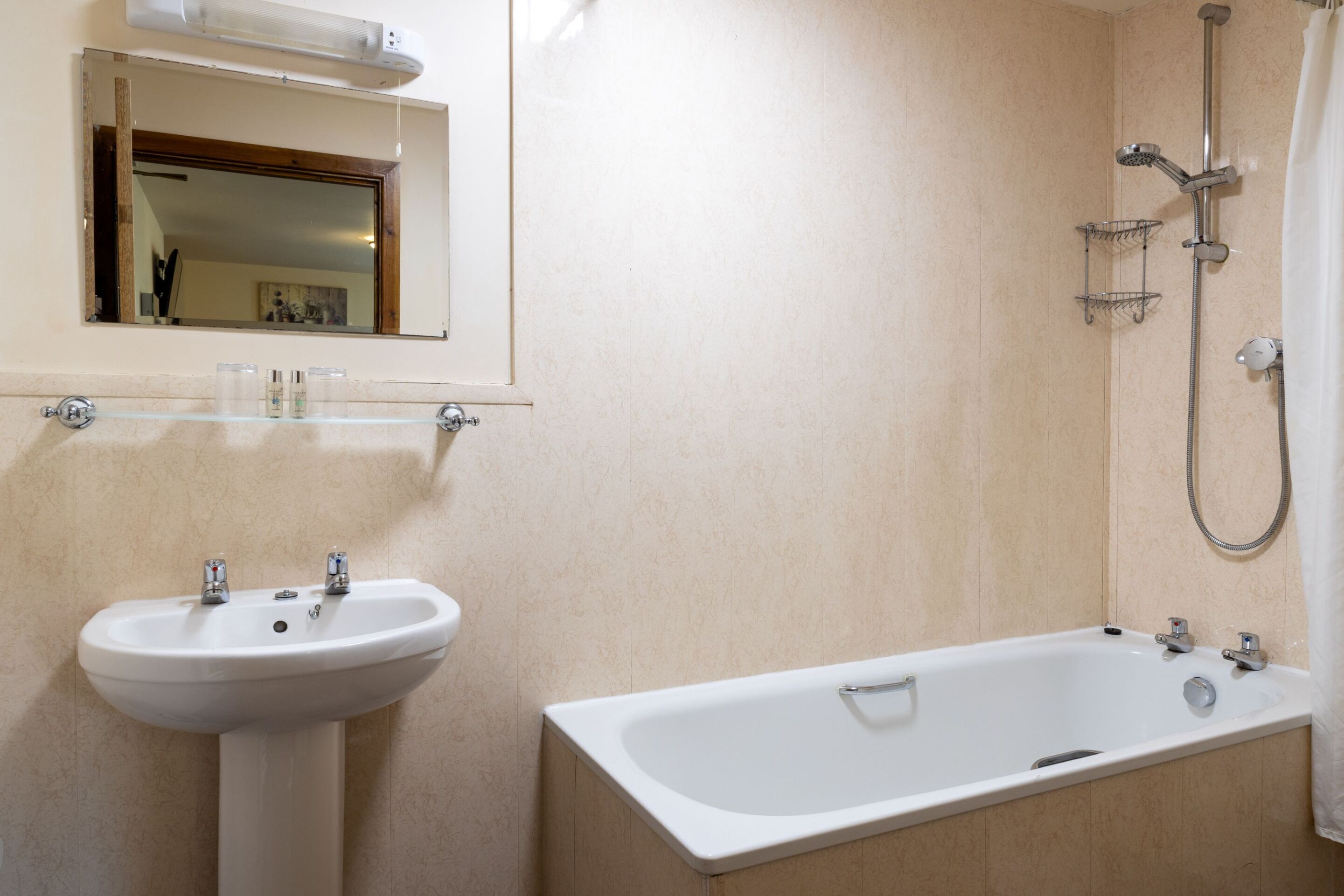 Un bagno con lavandino, specchio e vasca da bagno.