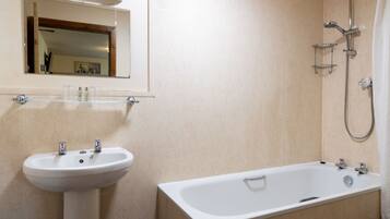 Un bagno con lavandino, specchio e vasca da bagno.