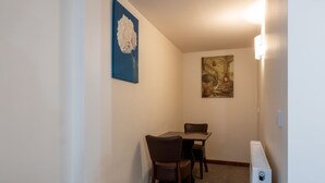 A narrow hallway with a dining table and chairs, a radiator, and two wall-mounted artworks. - The Warehouse (Yeovil)