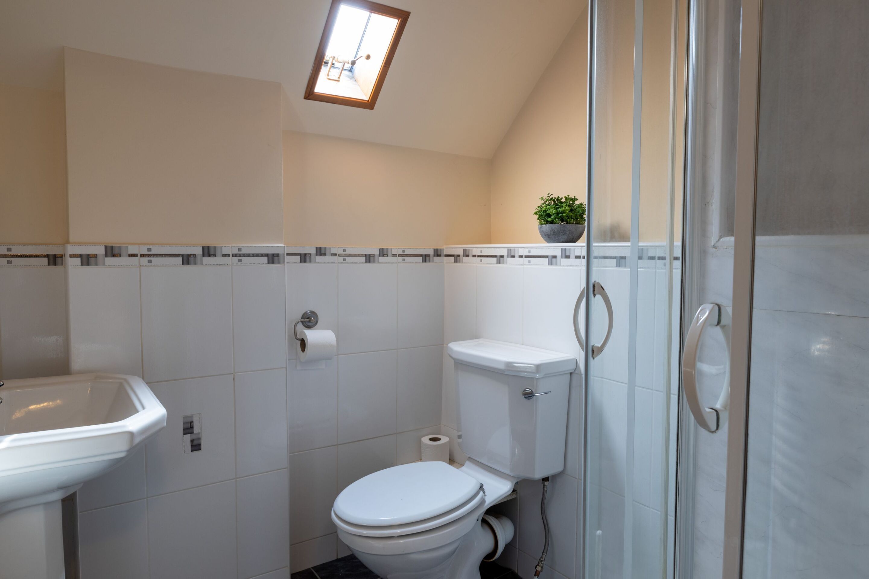 Un baño con inodoro, lavabo y ducha.
