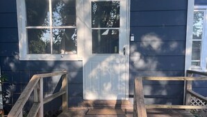 A wooden staircase leading to a door with two windows, surrounded by a wooden deck and a brick pathway. - Last Minute opening! Dog friendly place! Fenced yard! 3 bed!  (Superior)