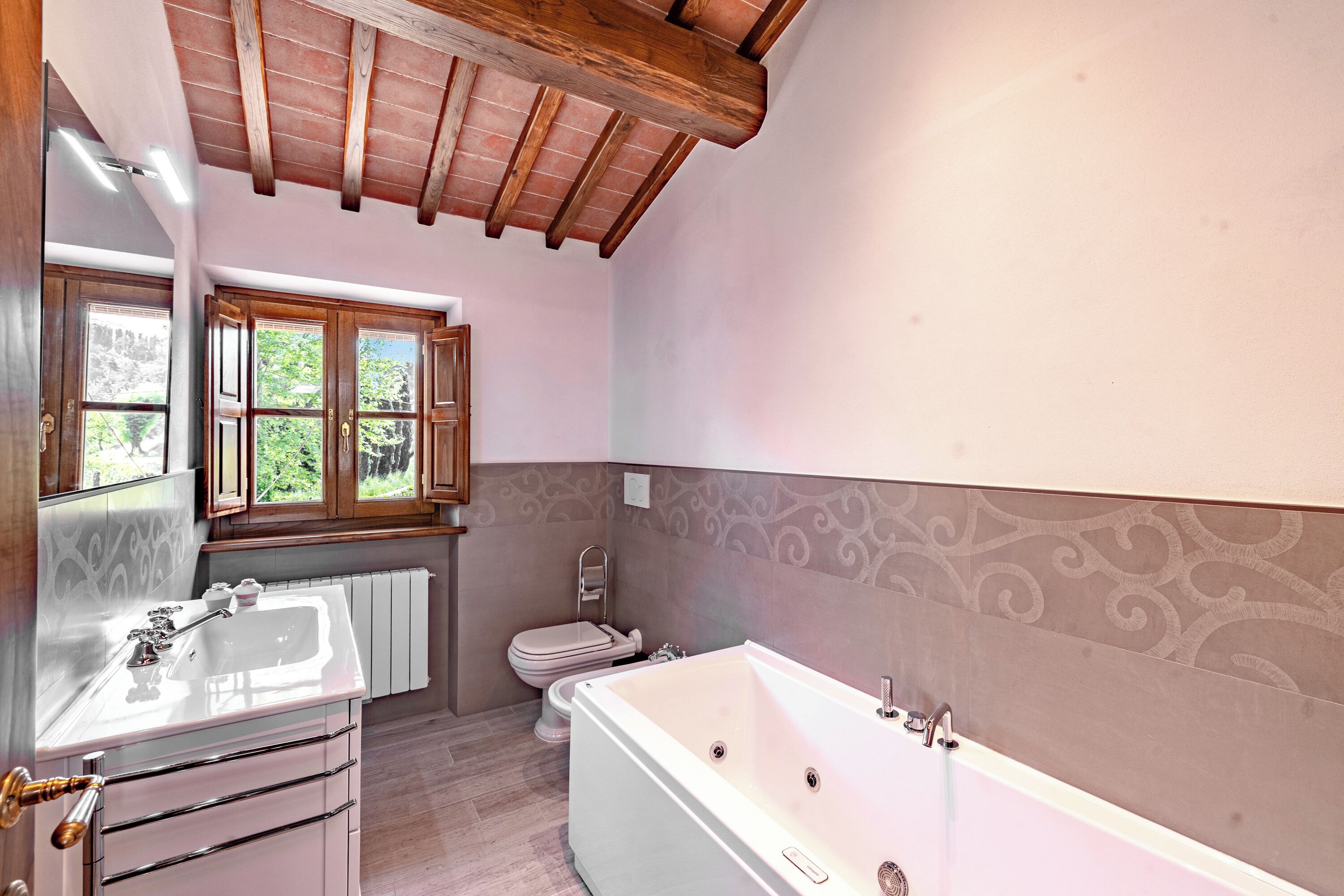 Une salle de bain avec une baignoire, un lavabo, des toilettes et une fenêtre.