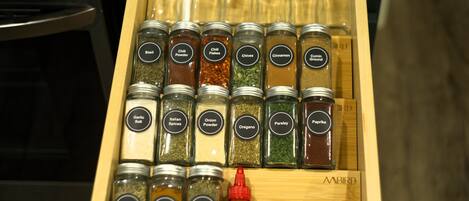 Un tiroir contenant diverses épices et herbes, notamment du basilic, du piment en poudre et de la cannelle.
