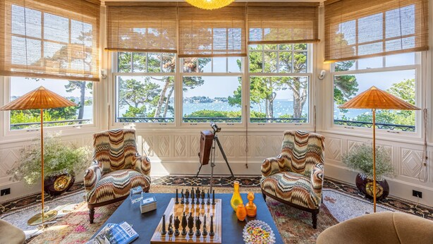 A room with large windows, a chessboard, and two patterned armchairs. - Villa Haute Guais  (Dinard)