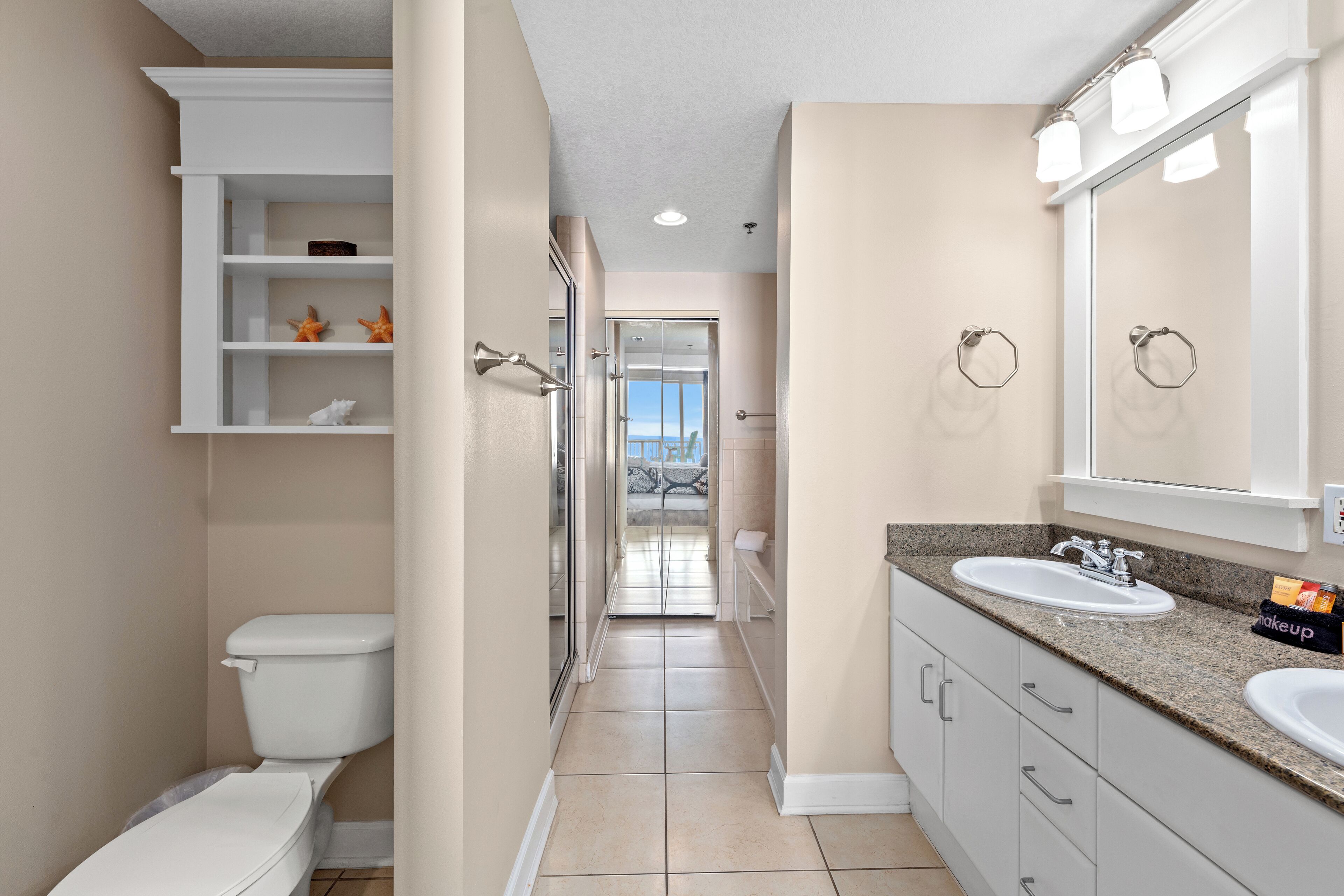 A modern bathroom with a toilet, sink, vanity, and a shower.