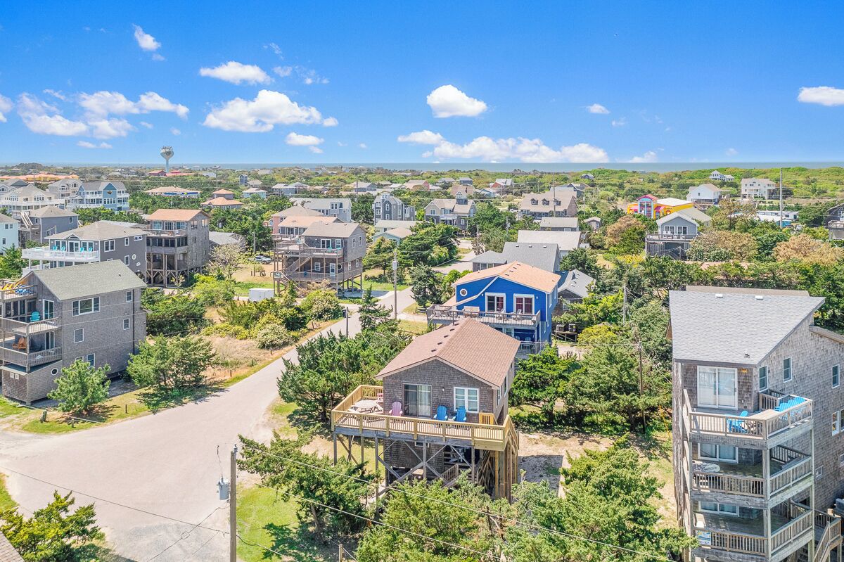 Un quartier résidentiel composé de maisons, dont certaines sont dotées de terrasses et de balcons, offrant une vue dégagée sur le paysage environnant.
