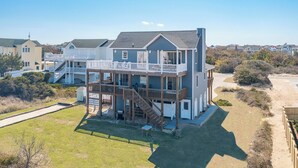 A two-story beachfront house with a balcony, a covered patio, and a small deck. - Well-appointed Corolla beach house, just steps from the beach! (Corolla)