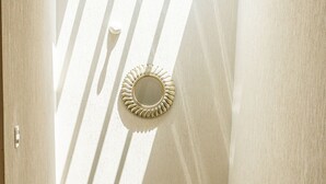 Una escalera con barandilla de metal conduce a una plataforma. Un espejo decorativo cuelga en la pared sobre la plataforma.
