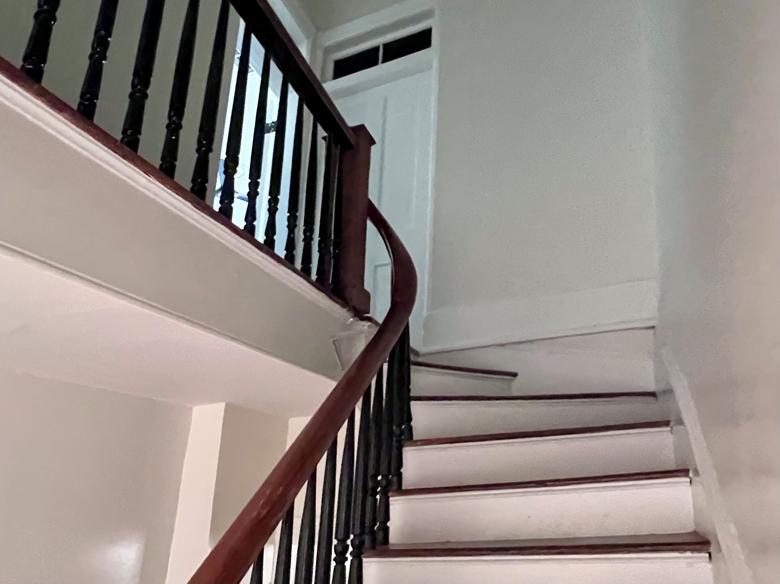 A staircase with wooden balusters and white steps.