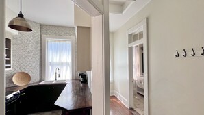 Una cocina moderna con una isla de madera, una lámpara colgante y vistas al área de comedor contigua.