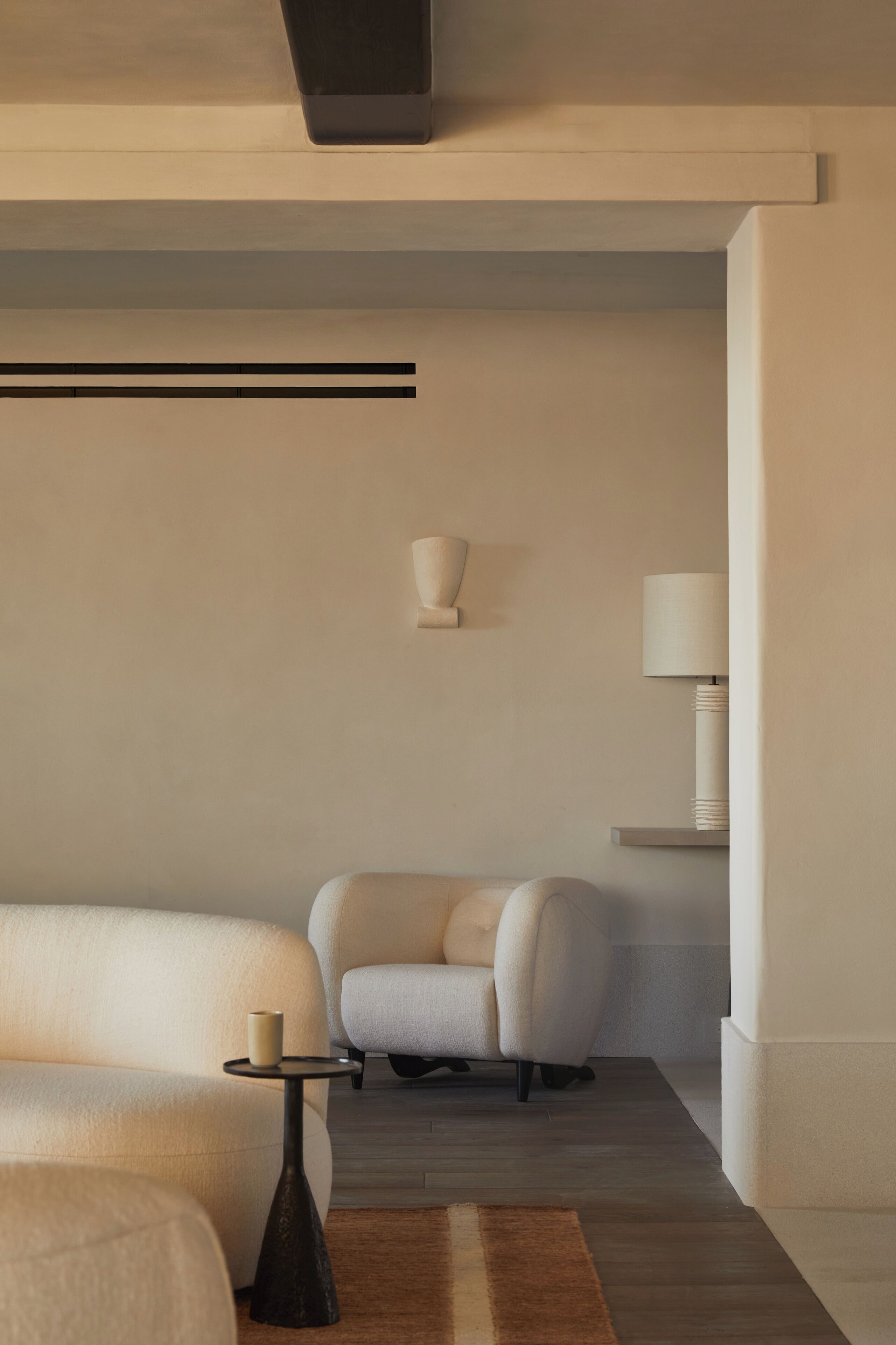 A modern living room with a sofa, armchair, and a small table.