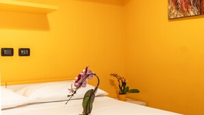 A hotel room with a bed, a tray with cups and a plant, and a painting on the wall. - 4bnb - Reale House Tulipano (Rome)