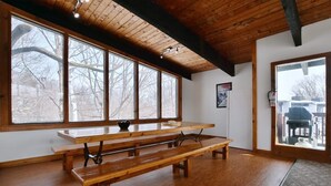A wooden bench with a bowl of fruit, large windows, and a door leading outside. - Blue Mountain Gem (R) near the Village (Town of Blue Mountains)