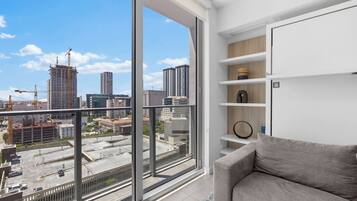 Deluxe Condo, Balcony, City View | Living area | 50-inch plasma TV with cable channels