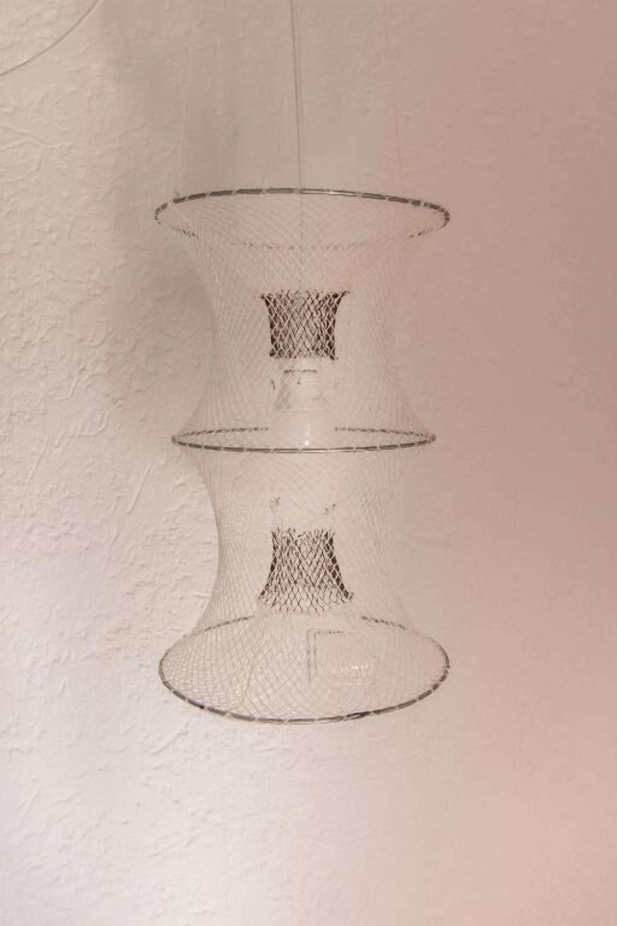 Estructura de estantería transparente y de alambre, con tres niveles y fijada a la pared.
