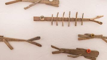 Una pared con pinzas de madera sujetando objetos en diferentes formas.
