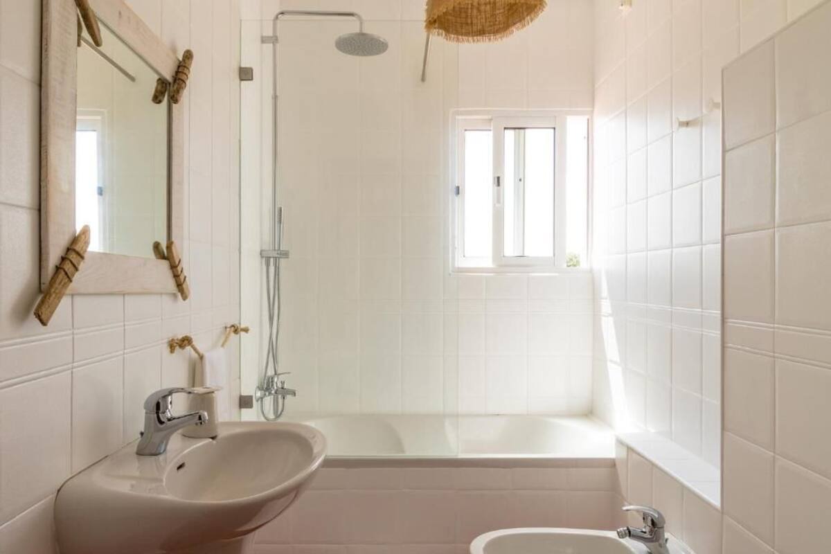 A modern bathroom with a large bathtub, a separate sink, and a shower.