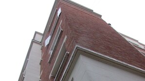 Un immeuble à plusieurs étages, doté d’une façade en briques rouges et de murs extérieurs blancs.
