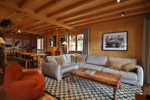 A cozy living room with a sectional sofa, a wooden coffee table, and a patterned rug.