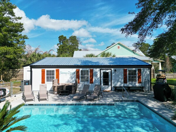 A poolside area with a pool, lounge chairs, and a building labeled "Skinny-Dipping". - Private Pool! Hot Tub! Golf Cart! Bikes! Walk to Beach! Paddle Boards! (Panama City Beach)