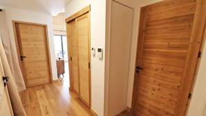 A hallway with wooden doors and a wooden floor.
