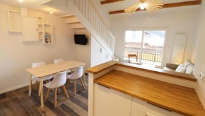 A modern kitchen with a wooden countertop, a dining area with a table and chairs, and a staircase leading to an upper level. - 300m from ski slopes, 3rd floor, balcony, 50m², Les Gets (Les Gets)