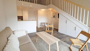 A modern living room with a sofa, a coffee table, and a dining area with chairs. - 300m from ski slopes, 3rd floor, balcony, 50m², Les Gets (Les Gets)