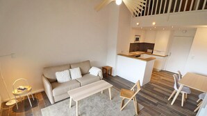 A modern living room with a sofa, a coffee table, and a dining area with chairs. - 300m from ski slopes, 3rd floor, balcony, 50m², Les Gets (Les Gets)