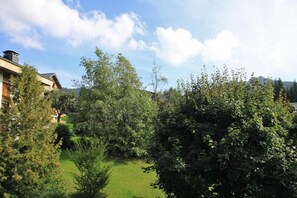 A residential area with a house, a lawn, and trees.