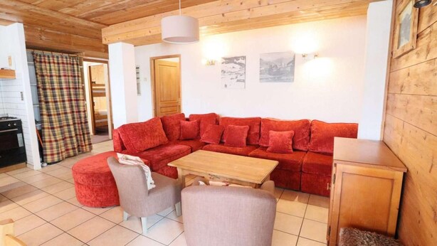 A cozy living room with a red sectional sofa, a wooden coffee table, and two armchairs. - Ground floor, parking, tv, 97m², Les Gets (Les Gets)
