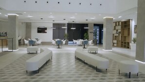 A modern lobby with white sofas, a reception desk, and a large plant. - Bayazid Hotel (Setif)