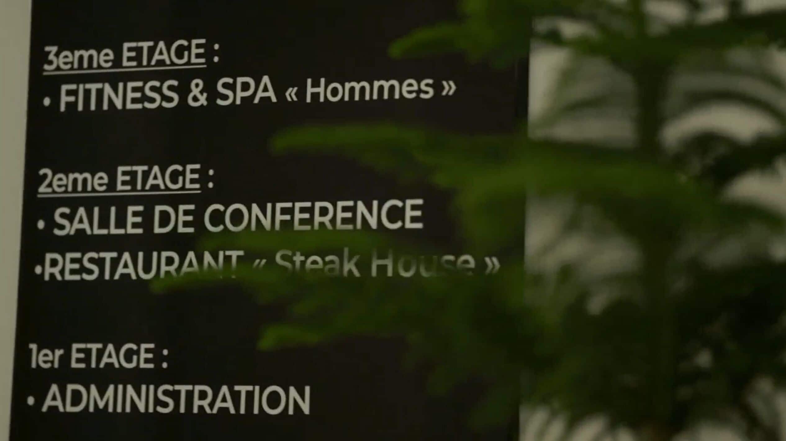 A sign listing the different stages of a hotel or conference center, including fitness and spa facilities, a conference hall, a restaurant, and administration.