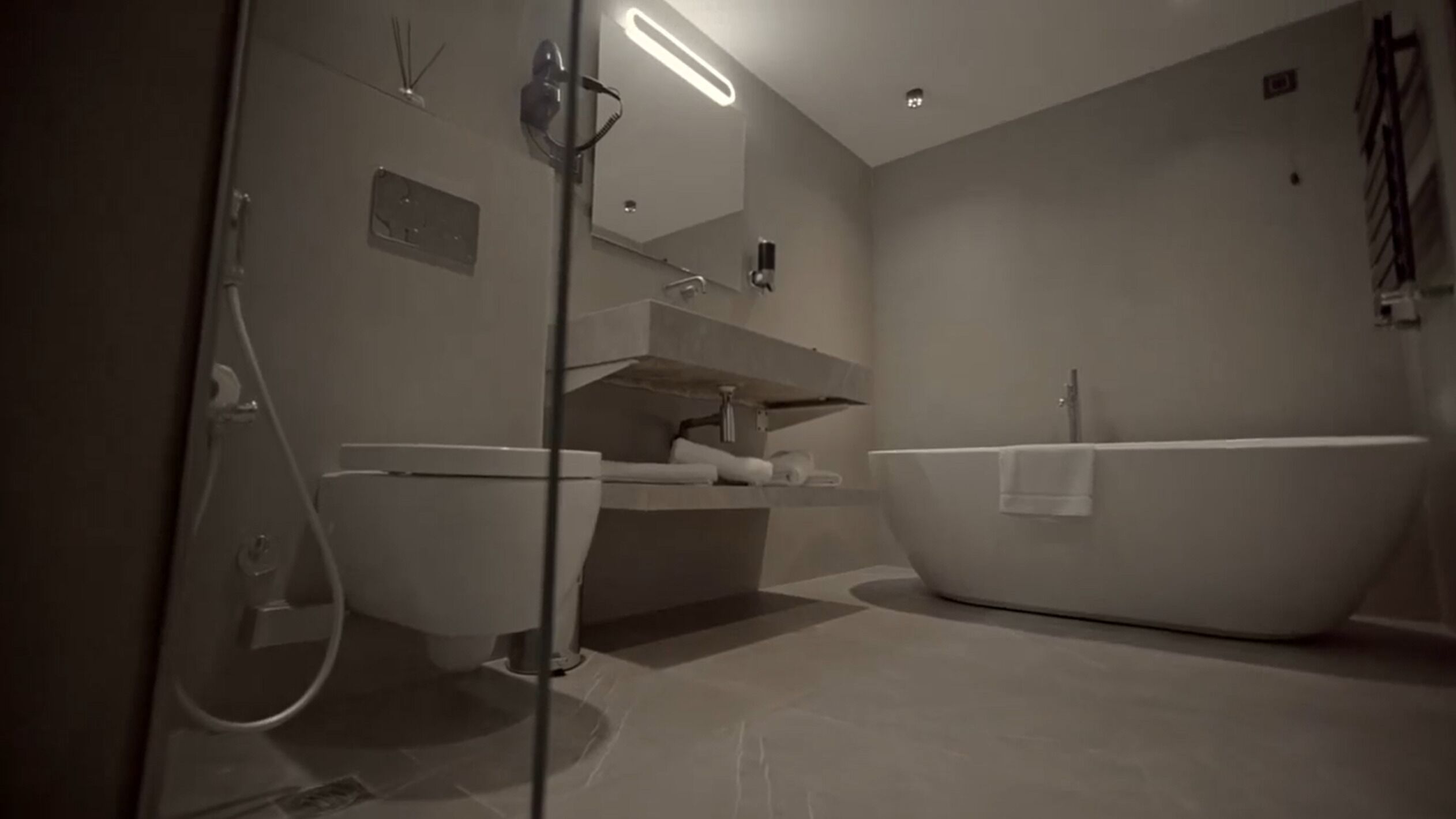 Un baño moderno con una bañera independiente, un tocador con espejo y una zona de ducha.