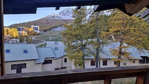 A view of a building with multiple windows and a mountain in the background.