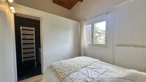Une chambre à coucher avec un lit, une fenêtre et un radiateur.