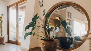 A room with a wooden floor, a large mirror, and a potted plant. - Monte da Vilarinha (Aljezur)