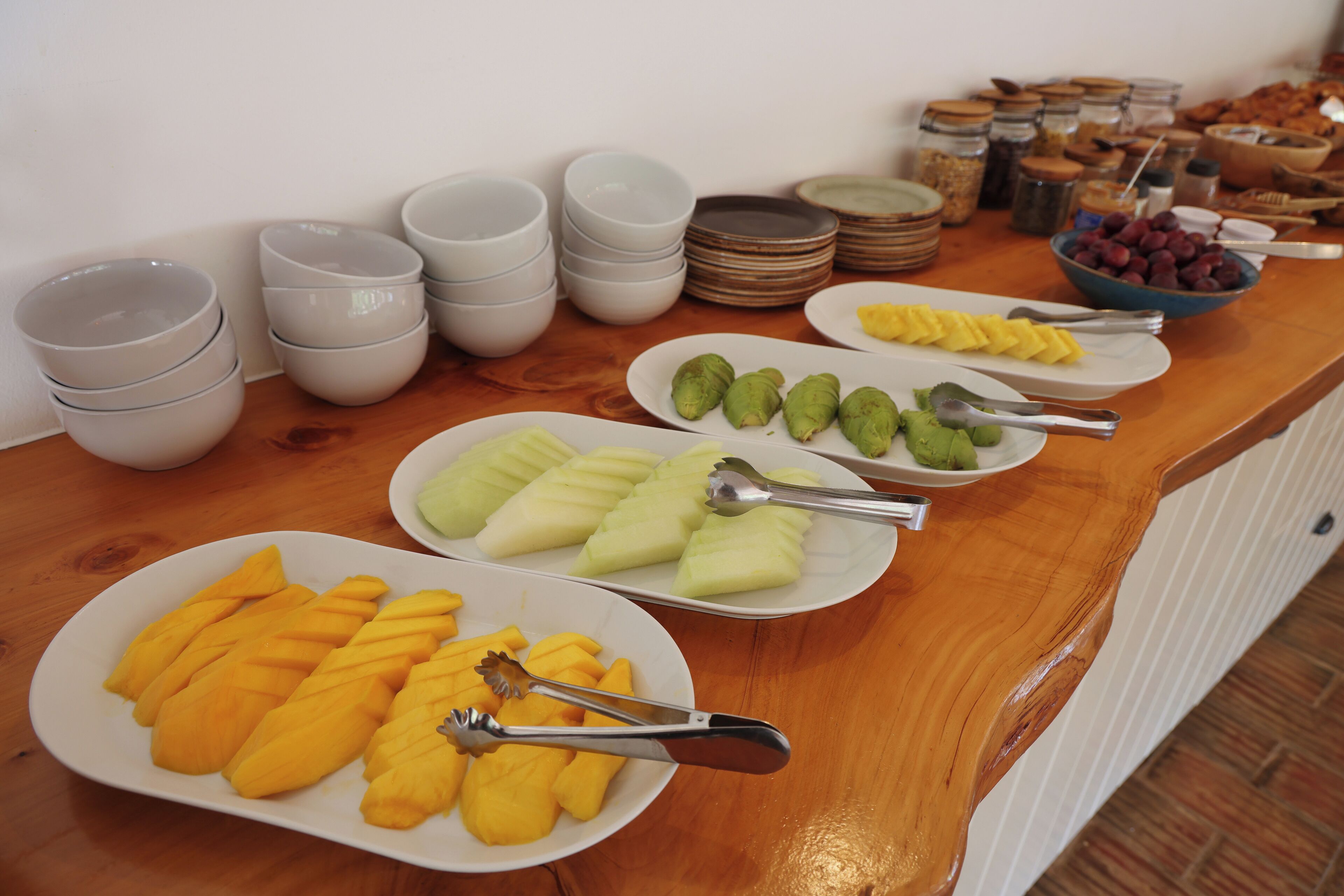 A buffet table with various food items and serving utensils.