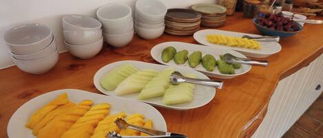 A buffet table with various food items and serving utensils.