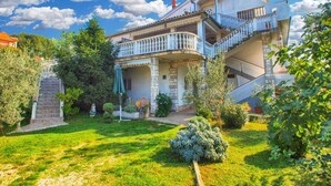 A two-story house with a balcony, a staircase, and a garden. - Holiday apartment with air conditioning (Medulin)