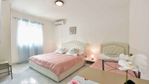 A bedroom with a bed, bedside table, lamp, and an air conditioning unit. - Studio with air conditioning (Poreč)