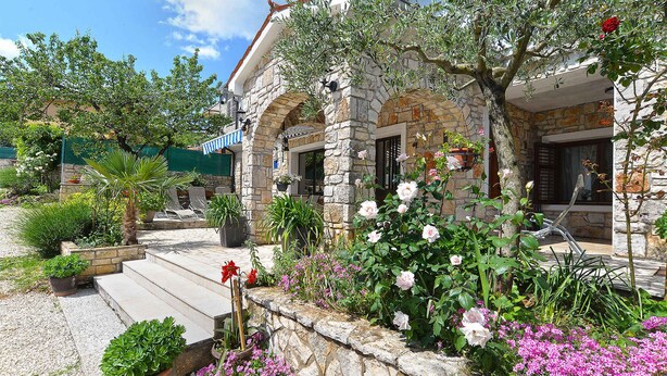 A stone building with a garden in front, featuring steps leading to the entrance. - Holiday apartment with balcony and air conditioning (Rovinjsko Selo)