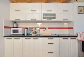 Køleskab, mikrobølgeovn, kogeplade, køkkentøj/tallerkener/redskaber