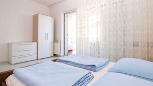 Ein Schlafzimmer mit Bett, Kleiderschrank und einer Tür zu einem Außenbereich.