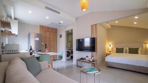 A modern hotel room with a sofa, a TV, a dining area, and a bedroom. - Bomo Suites (Konyaalti)