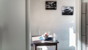 A dining area with a table, chairs, and a laptop. There are two framed pictures on the wall. - La Finestra sul Lago (Cernobbio)