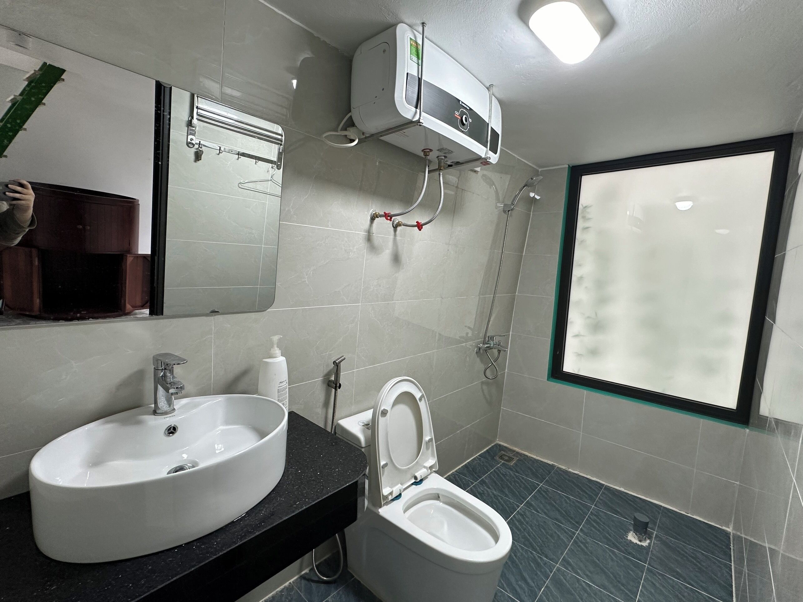 A modern bathroom with a sink, toilet, and shower.